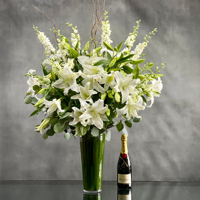 This Display of over 20 Stems of Crystal White Lily's accented with locally Grown Flowers and Greens is available for same day Delivery at Beverly Hills Florist. This Bouquet is placed in a leaf lined 14" Tall vase with an opening of 5" and it is Approx. 45" Tall and 32 Wide. Birthday Flowers, Just because flowers, thinking of you flowers